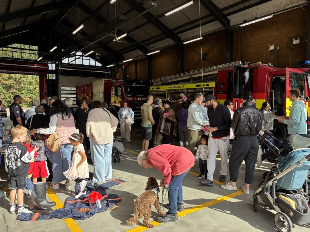 Barnet fire station holds family open day with youngsters queuing up to sit in fire engine can and mums and dads learning about challenges for rescue services.